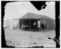  Visitors and fellow campers in the Wrights' work shed at Kitty Hawk, North Carolina. Left to right: Octave Chanute, Orville Wright, and Edward C. Huffaker seated at left and Wilbur Wright standing.

