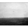 Model B in flight over a field.
