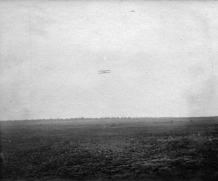Model B in flight over a field.