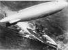 An aerial view of the U.S. Navy dirigible ZRS-4 (Akron) superimposed above a battleship.